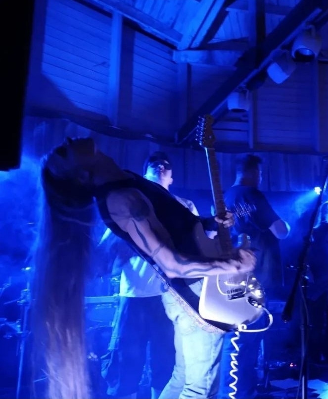 Translator Timo Tuimala of Tuimala Traducciones playing the guitar at a gig.